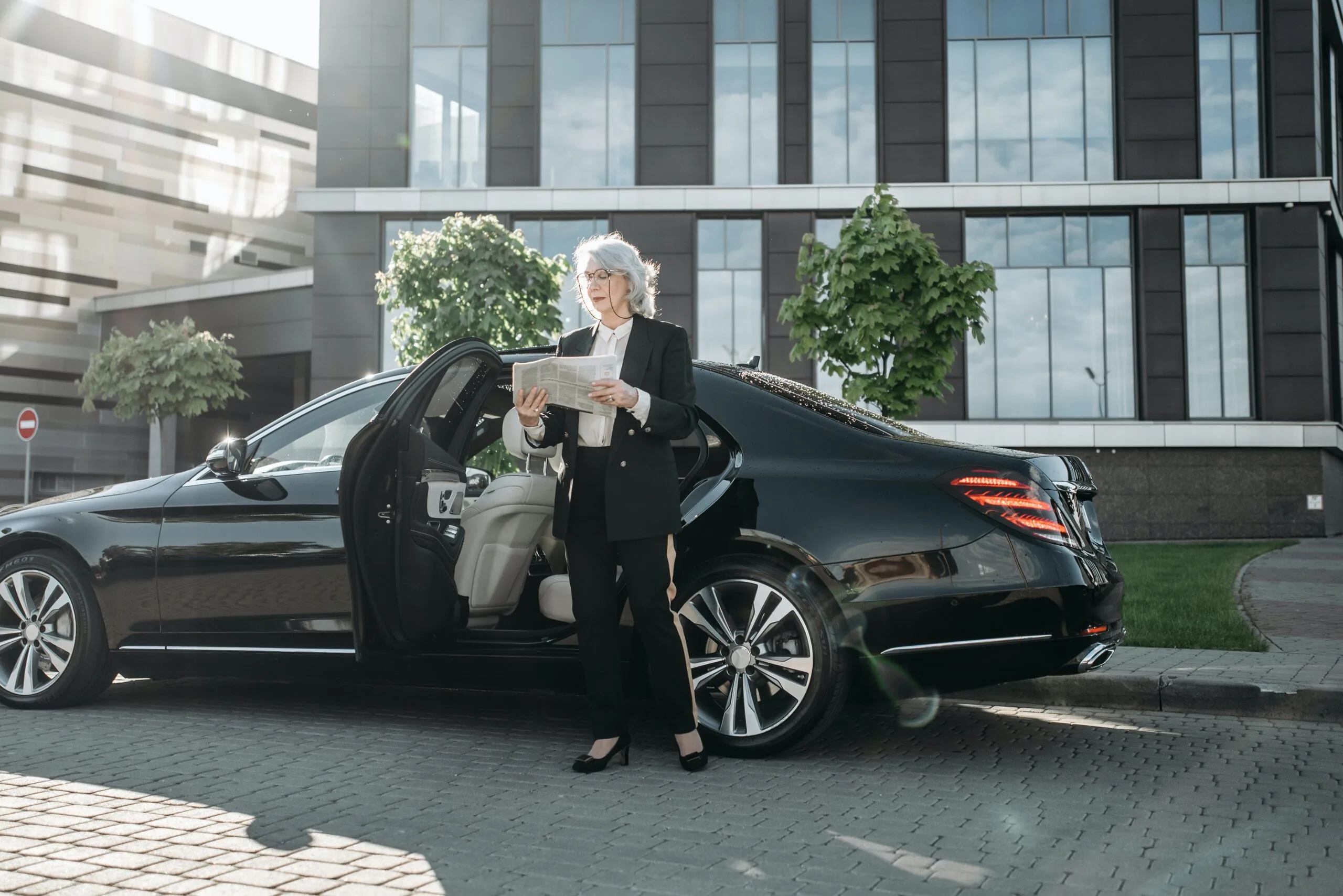 Banner image showing a luxurious black car with a happy customer ready for a premium chauffeur service, ideal for corporate, business, and airport transfers.