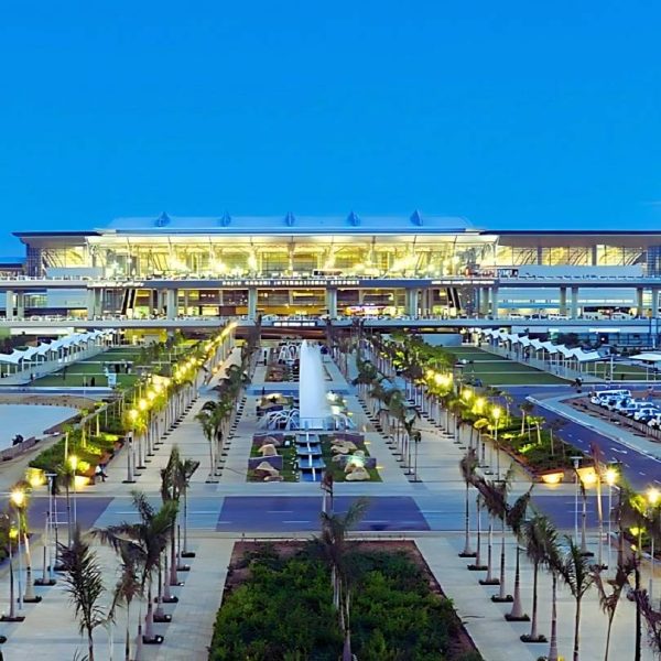 ProRido luxury chauffeur waiting at modern airport arrivals palm trees twilight