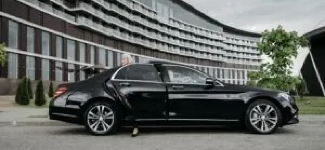 Luxurious black car with a smiling customer, ideal for premium chauffeur, airport transfer, and business travel services.